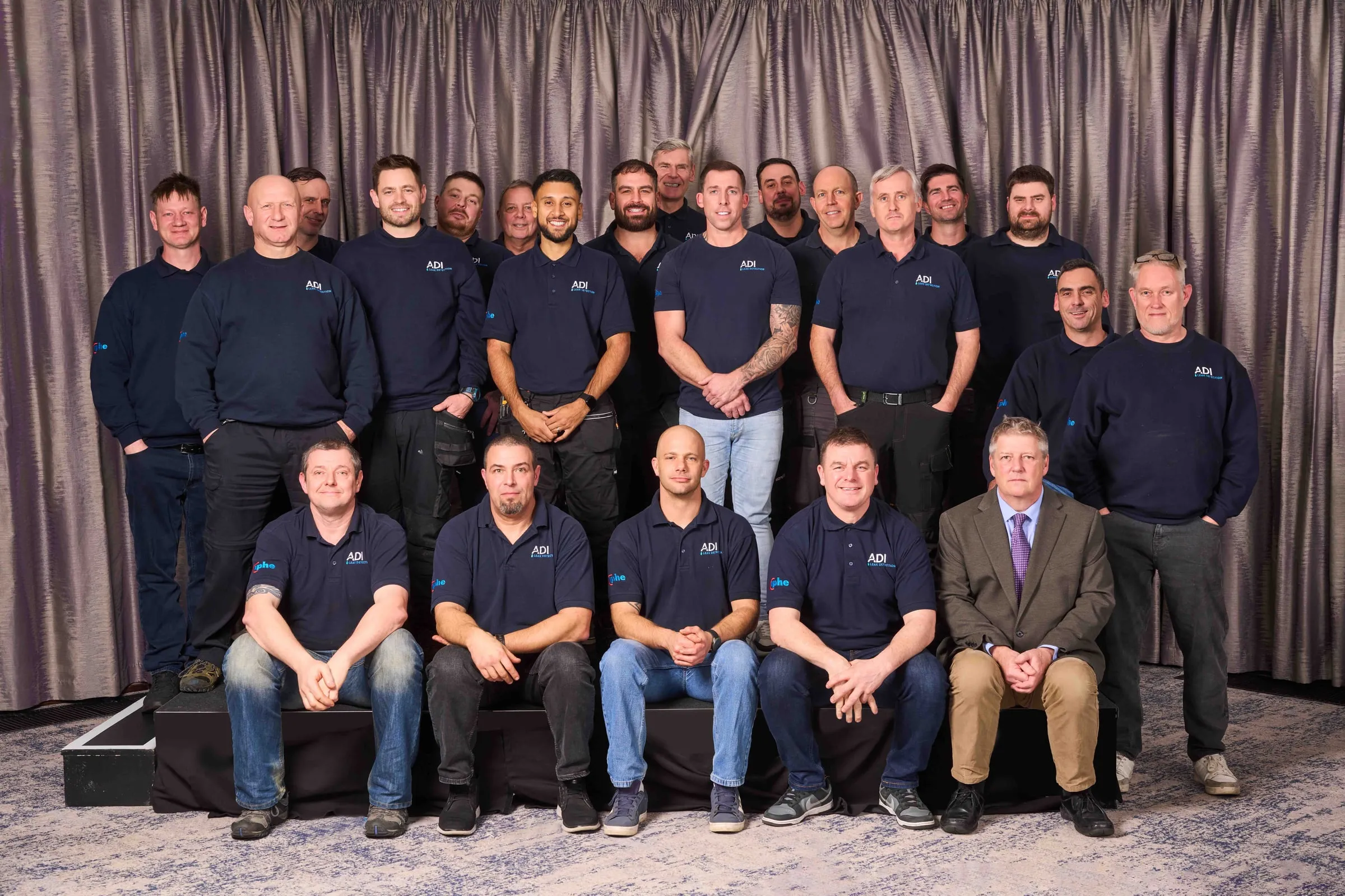 Group photograph of ADI Leak Detection’s engineers in navy company uniforms